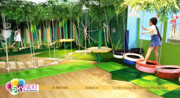Trẻ em bước trên lốp treo và cầu gỗ trong khu chơi chủ đề rừng