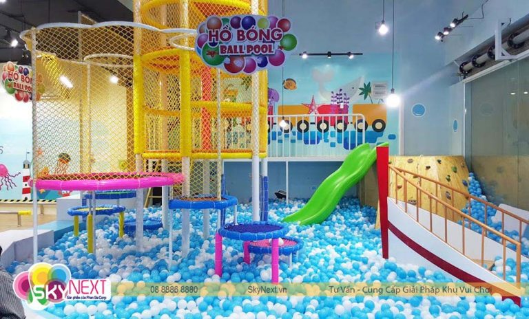 Hồ bóng trong nhà cho trẻ em với cầu trượt xanh và cấu trúc leo núi