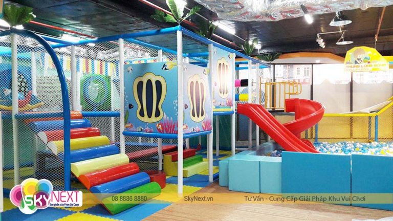 Khu vui chơi trẻ em trong nhà với cầu trượt đỏ và bể bóng nhiều màu
