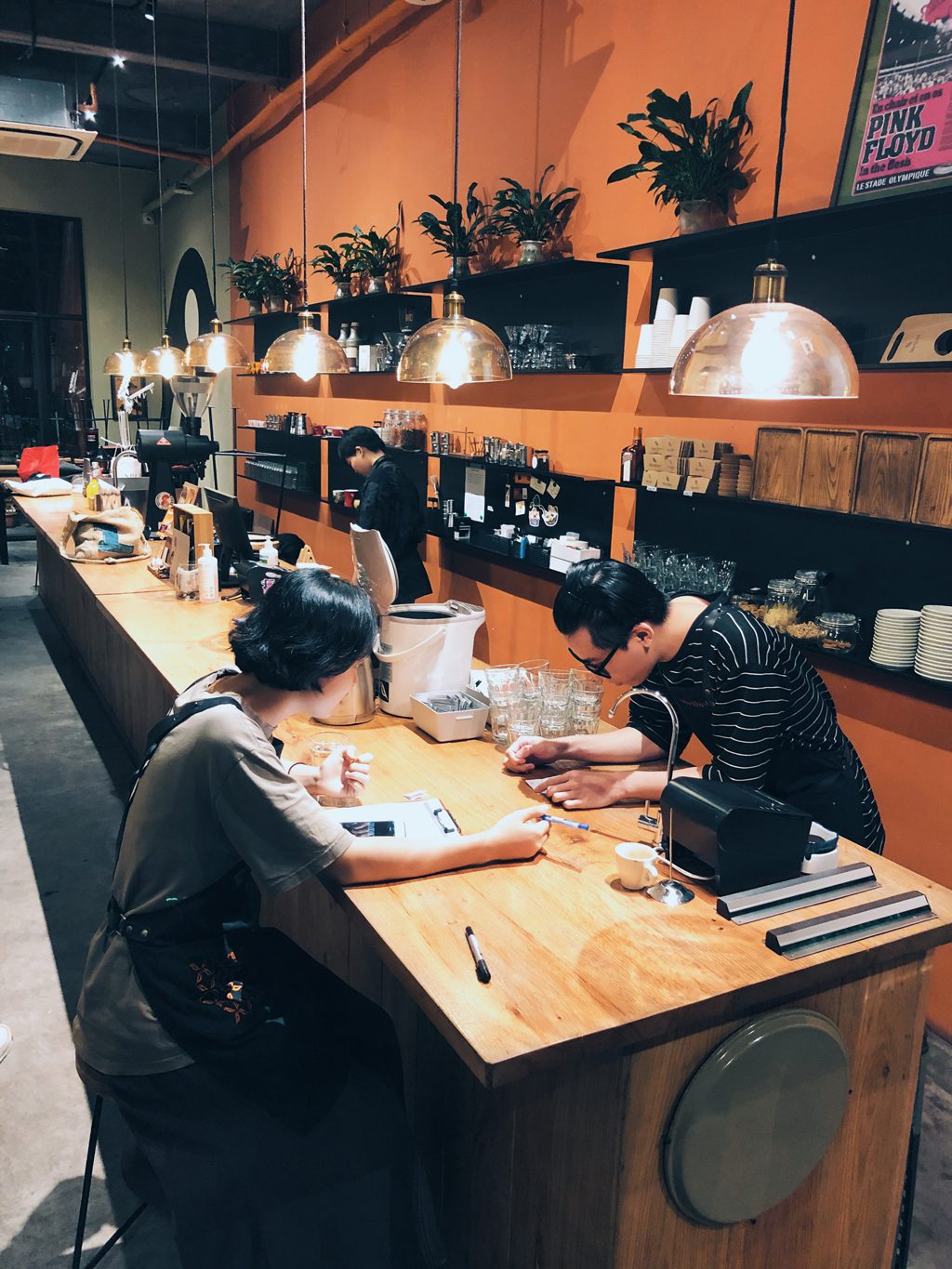 Processed with VSCO with a2 preset Khách và barista bên quầy gỗ trong quán cà phê phong cách tối giản