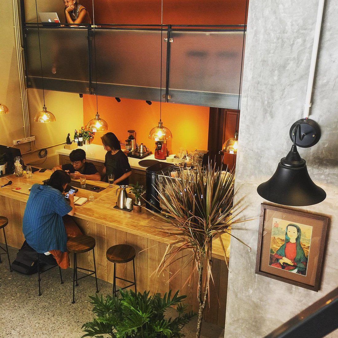 Blackbird Coffee Hà Nội 8 Quầy pha chế gỗ nhỏ trong quán cà phê, đèn vàng ấm và khách ngồi làm việc