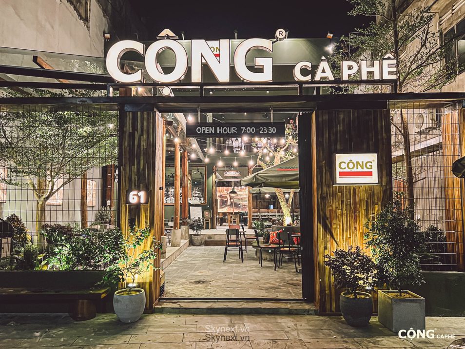 Mặt tiền quán Cộng Cà Phê về đêm, biển hiệu sáng và lối vào mở