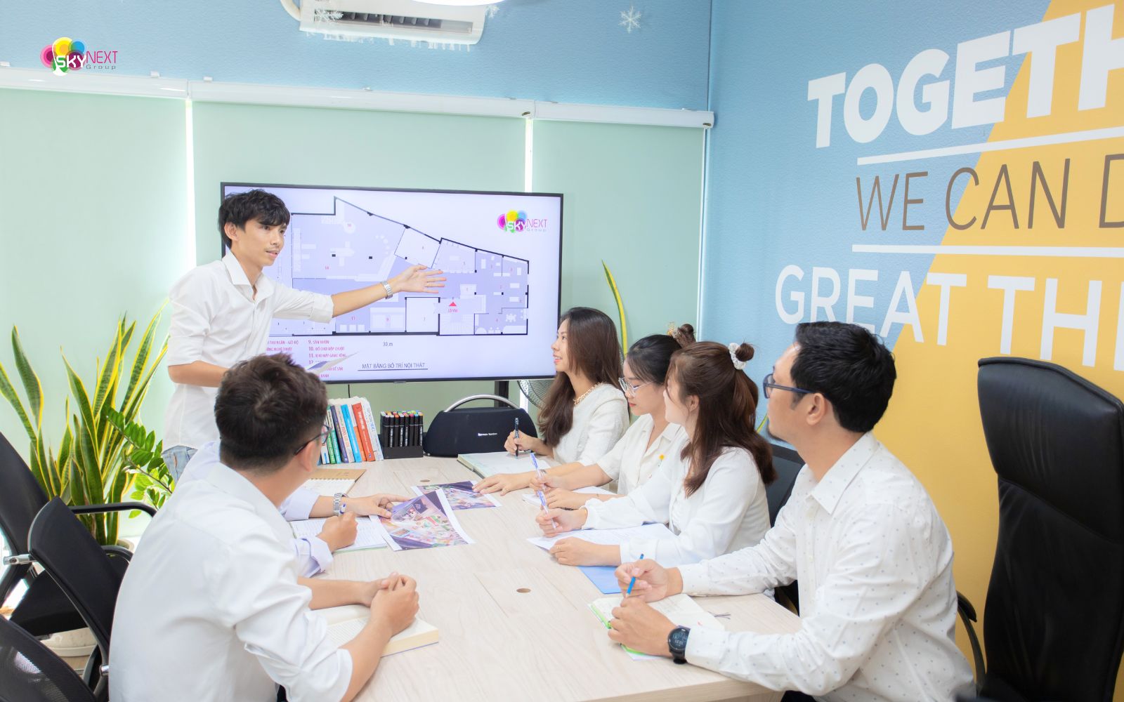 Đội Ngũ Nhân Sự 1 Nhóm nhân viên SkyNext họp thảo luận bản vẽ mặt bằng trên màn hình trong phòng họp